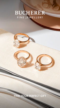 three gold rings sitting on top of a white cloth