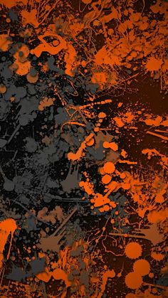 an orange and black background with paint splattered on it's surface,