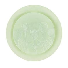 a green bowl with flowers etched on it's side and in the center is an image of tulips