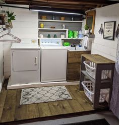 a laundry room with washer, dryer and drying rack on the floor in front of it