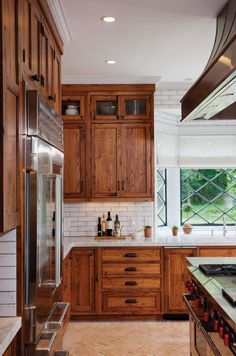 a kitchen with wooden cabinets and marble counter tops