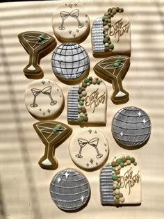 decorated cookies are arranged in the shape of martini glasses and globes with words happy new year written on them