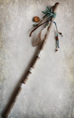 a wooden stick with feathers and beads on it