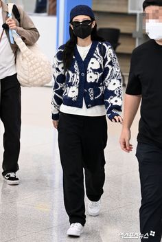 a woman wearing a face mask while walking through an airport