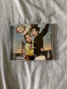 a cd with an image of a man and woman holding each other on top of a bed