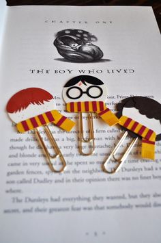 harry potter bookmarks are sitting on top of an open book with the title'the boy who lived '