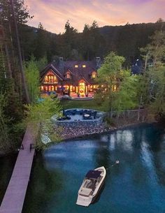 an aerial view of a house with a dock in the foreground and boats on the water