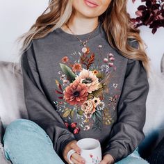 "You will love this floral sweatshirt! It has a cute, minimalist design and is sure to give you all the warm fuzzy feelings while wearing it. These crewnecks are really soft and super comfortable for lounging around at home or for wearing out and about. These cozy crewnecks make great birthday gifts for your best friend or anyone else :) *PRODUCT DESCRIPTION* -Gildan 18000 Unisex Crewneck Sweatshirt -50% cotton, 50% polyester -Medium-heavy fabric -Sewn-in label -Shirt colour may vary slightly du Cotton Floral Print Sweatshirt For Fall, Casual Fall Floral Tops, Fall Floral Print T-shirt, Fall Casual Sweatshirt With Plant Print, Casual Plants Print Sweatshirt For Fall, Floral Print Spring Sweatshirt, Flower Shaped Relaxed Fit Sweatshirt For Fall, Relaxed Fit Flower Sweatshirt For Fall, Flower Sweater