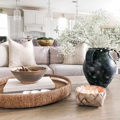 a living room filled with furniture and a large vase on top of a coffee table