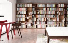 a bedroom with a bed, desk and bookshelf filled with lots of books