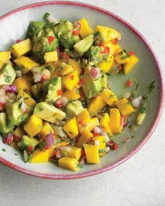 a bowl filled with fruit and vegetables on top of a white tablecloth next to a fork