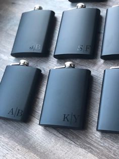 six black flasks sitting on top of a wooden table