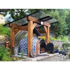 an outdoor pizza oven built into the side of a stone wall