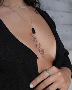 a woman's chest with a flower tattoo on the left side of her stomach