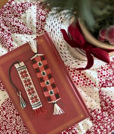 a red book sitting on top of a table next to a vase filled with flowers