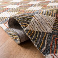 a close up of a rug on the ground with wood flooring and wooden floors