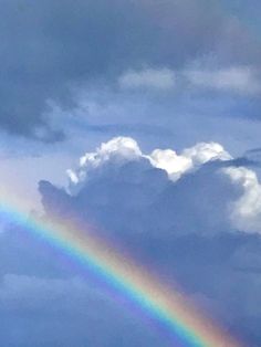 a rainbow in the sky with clouds behind it