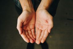 a person holding their hands in the air with one hand on top of each other