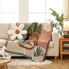 a living room with a couch, coffee table and flowers on the side tables in front of it