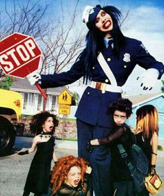 a group of young women standing next to each other in front of a stop sign