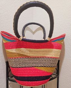 Discover the beauty of our handcrafted Bolga Basket Purse, woven by skilled women artisans from Bolgatanga, Ghana. Made from durable, eco-friendly elephant grass, this purse showcases vibrant colors and intricate patterns, reflecting the rich tradition and craftsmanship of the region. Versatile and stylish, it can be used as a handbag, a unique storage solution, or a decorative piece. Your purchase not only adds a beautiful accessory to your collection but also supports the artisans' primary sou Artisan Multicolor Straw Bag As Gift, Artisan Multicolor Straw Bag For Gift, Multicolor Artisan Straw Bag, Traditional Natural Straw Bag For Market, Traditional Natural Straw Bag, Traditional Palm Leaf Straw Bag For Daily Use, Traditional Natural Straw Market Bag, Artisan Multicolor Straw Bag For Daily Use, Traditional Multicolor Straw Bag For Gifts