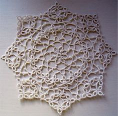 an intricate white doily on a table