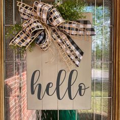 a welcome to our home sign hanging on the front door with burlocks and greenery