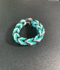 the bracelet is made from two different colored braids and has a metal clasp on it