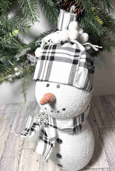 a snowman ornament with a plaid hat and scarf on it's head