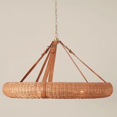 a chandelier made out of wicker with leather straps hanging from the ceiling