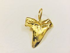 This vermeil shark tooth is a nice piece for necklaces, bracelets and earrings. It measures about 22x15mm including loop. It is 18k gold plated over 925 sterling silver (vermeil), shiny finished. 1 pc. SILVER VERSION: https://www.etsy.com/listing/219670150/925-sterling-silver-oxidized-shark-tooth MATTE VERMEIL VERSION: https://www.etsy.com/listing/242934154/vermeil-18k-gold-over-925-sterling SHINY ROSE GOLD VERSION: https://www.etsy.com/listing/464997918/rose-gold-vermeil-18k-rose-gold-over-925 Gold Arrowhead Jewelry Gift, Gold Arrowhead Jewelry For Gift, Silver Shark, Tooth Charm, Shark Tooth, Shark Teeth, 18k Rose Gold, Gold Vermeil, Necklaces Bracelets