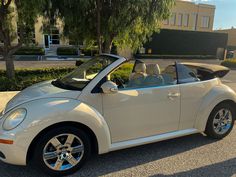 a white convertible car parked in front of a building