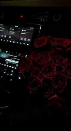 there is a car dashboard with roses on the dash and an electronic device in front of it