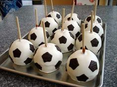 there are many soccer balls on the tray with toothpicks stuck in them to make them look like they're ready to play