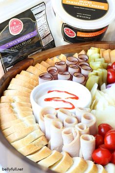 an assortment of cheeses, tomatoes and other foods are arranged in a bowl on a table