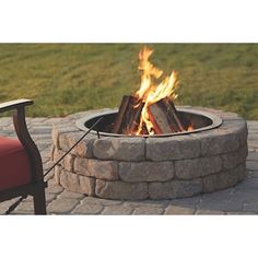 a fire pit sitting on top of a brick patio next to a red lawn chair