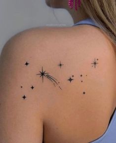 the back of a woman's shoulder with stars on it and a star in the sky