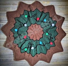 a crocheted christmas wreath on top of a wooden floor with lights in the center