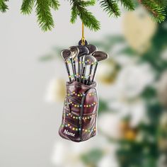 a golf bag ornament hanging from a christmas tree with golf clubs in it