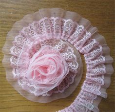 a pink flower on top of a lace doily