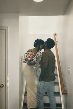 two people are standing on the stairs and one is holding a basket full of food