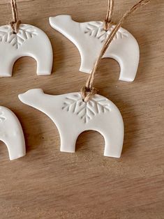 three white ceramic ornaments hanging from twine