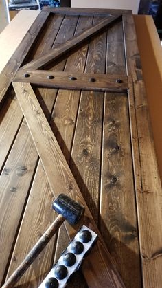 a close up of a wooden table with some tools on the ground next to it