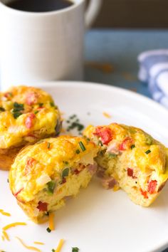 two breakfast muffins on a plate with a cup of coffee in the background