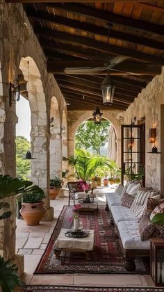 an outdoor living area with couches and potted plants