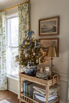 a decorated christmas tree in the corner of a living room with blue and white ornaments