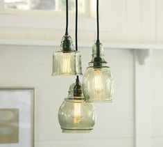 three light fixtures hanging from a ceiling in a kitchen