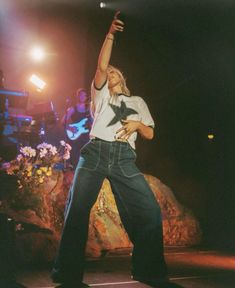 a man standing on top of a stage with his arms in the air