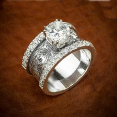 two wedding rings with an intricate design on each band and a center diamond in the middle