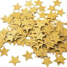 gold glitter stars are scattered on a white surface, as if they were used to decorate the